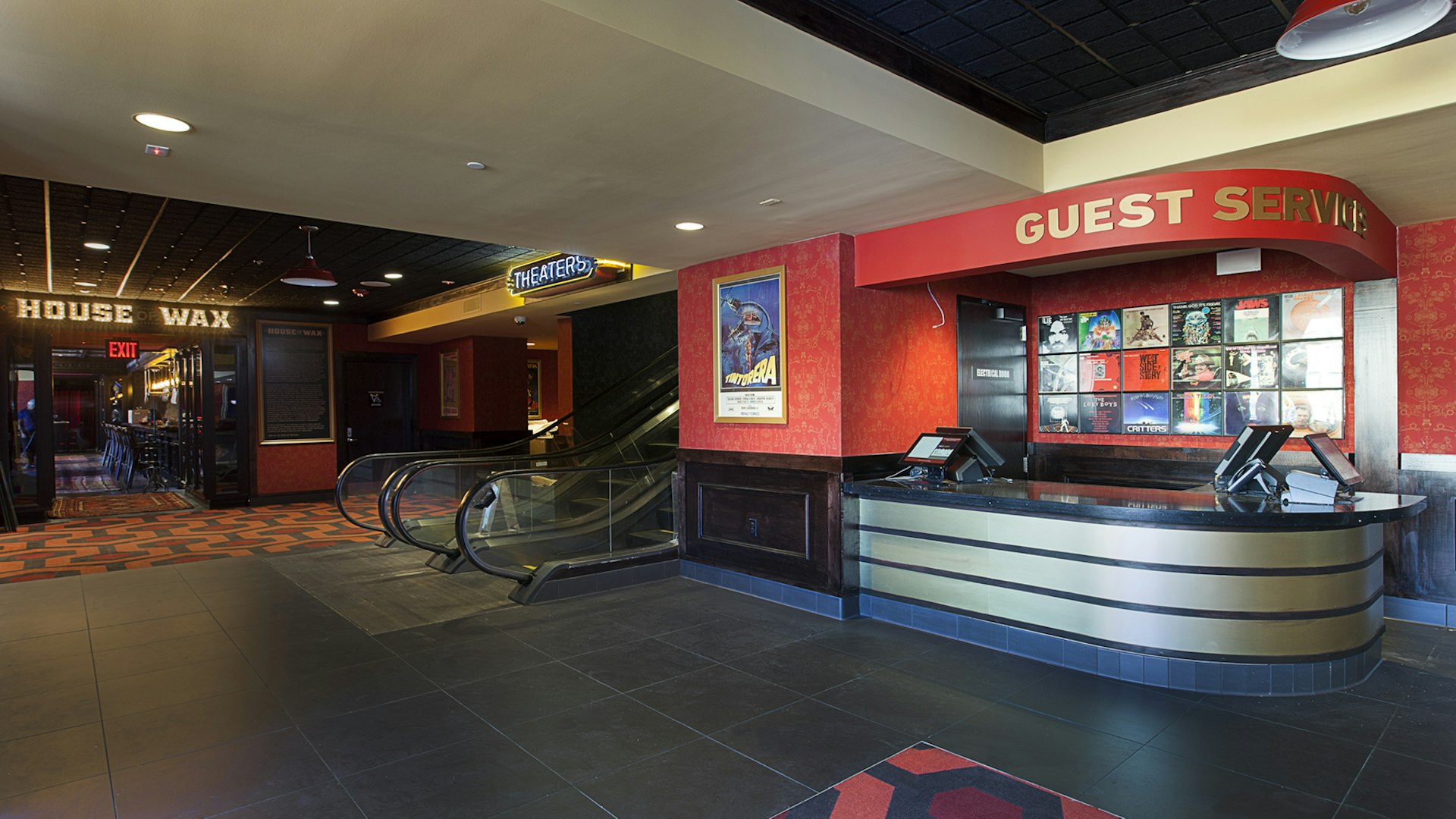 The lobby of Alamo Drafthouse in Downtown Brooklyn. A guest services desk is located to the right, and escalators to the left.